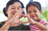 Woman & a girl making a heart shape