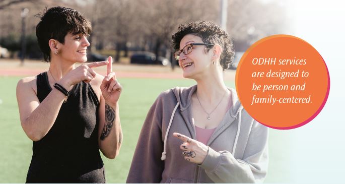 two people chatting in sign language at a park 